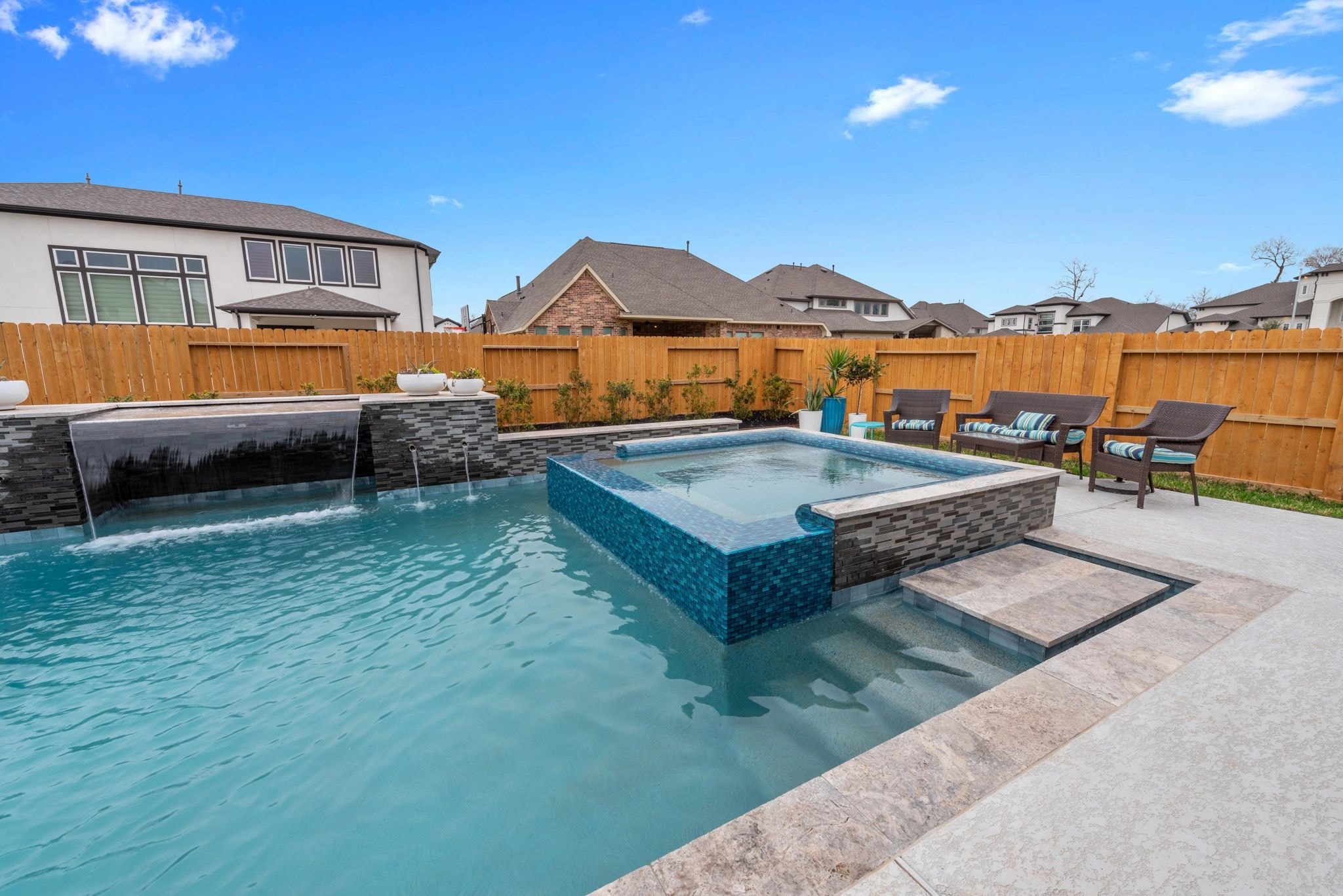 Luxury pool renovation with grotto, raised spa, fire pit, and updated coping