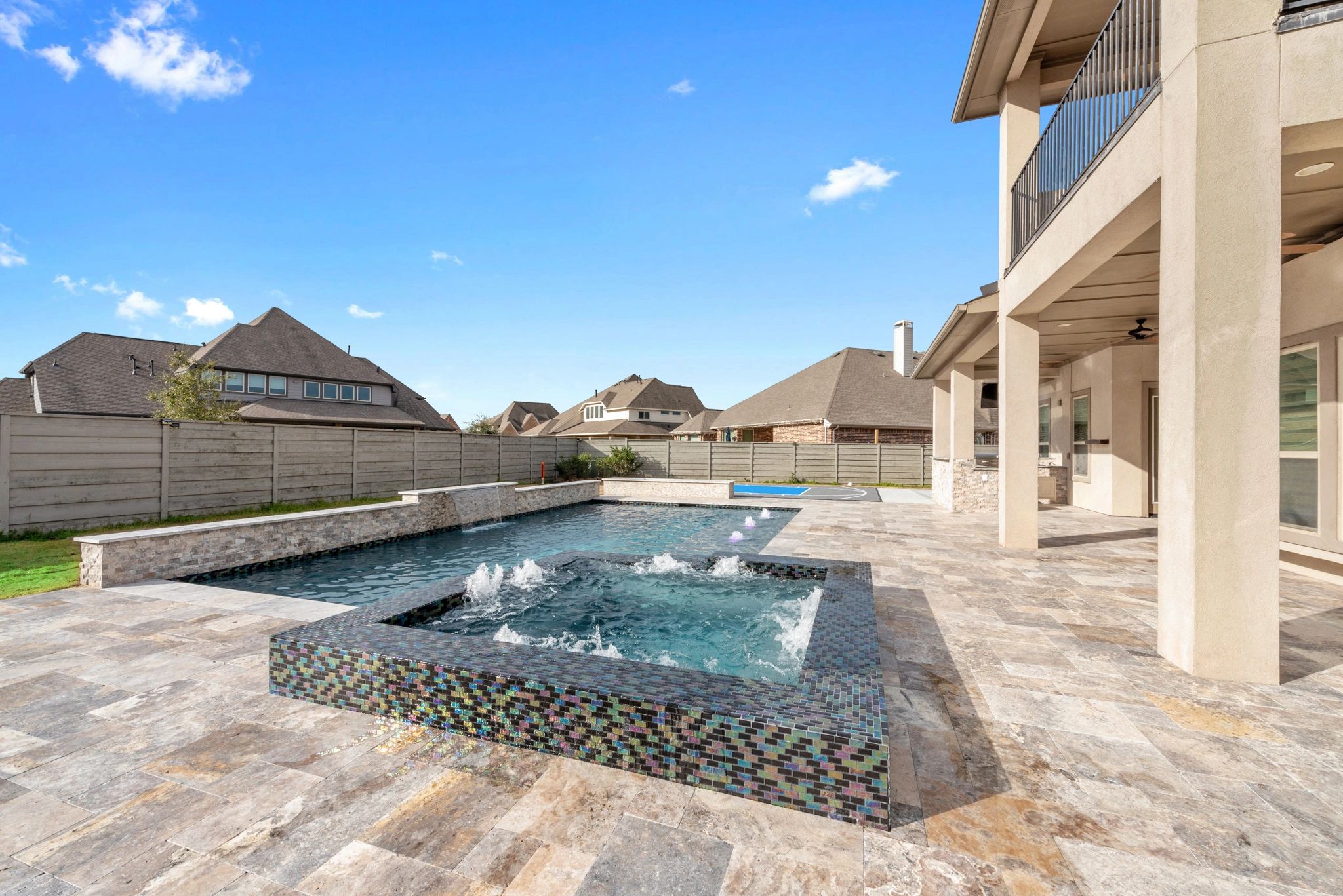 Finished backyard outdoor living space with pool and covered patio