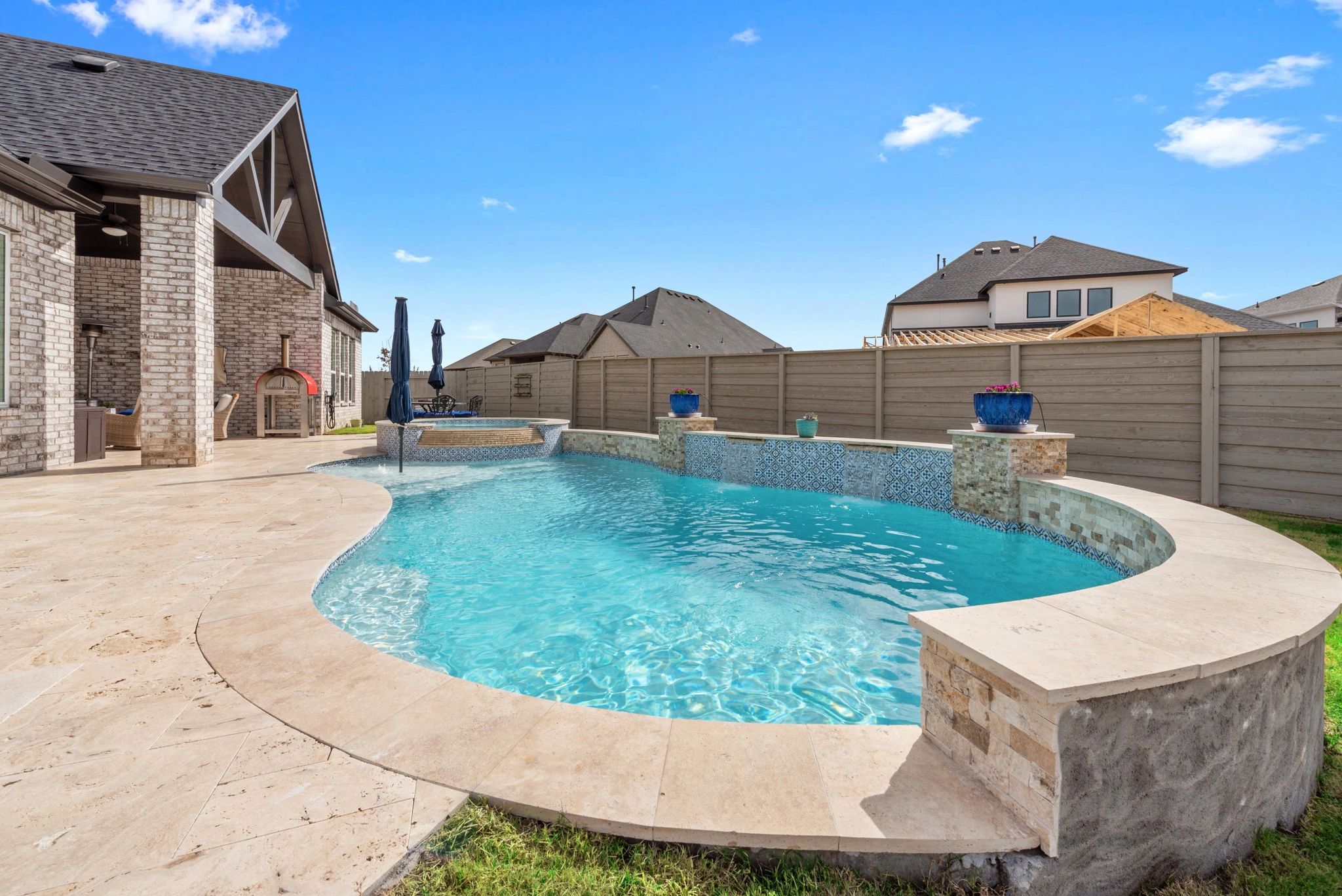 Travertine pool deck with custom coping and stone surround